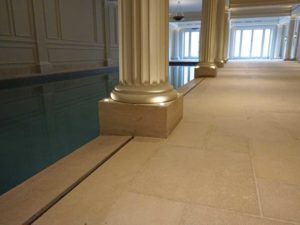 Agen limestone swimming pool tiles tiles, drainage grills, coping stones and column bases. Lias Blue porcelain tiles for inside the pool.